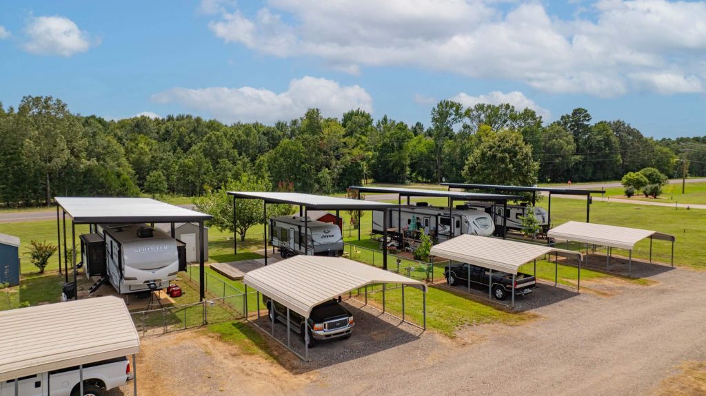 Custom RV cover 20 feet wide and 14 feet high sheltering an RV at Antique Capital RV Park, Gladewater TX.