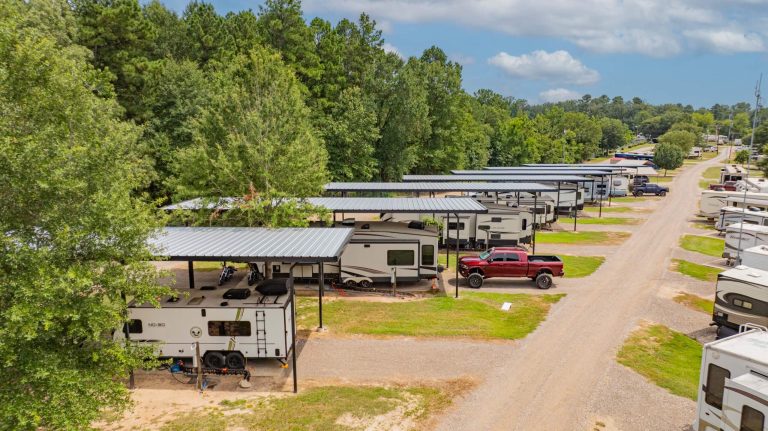 Covered RV site with green space on each side at Antique Capital RV Park, Gladewater TX.